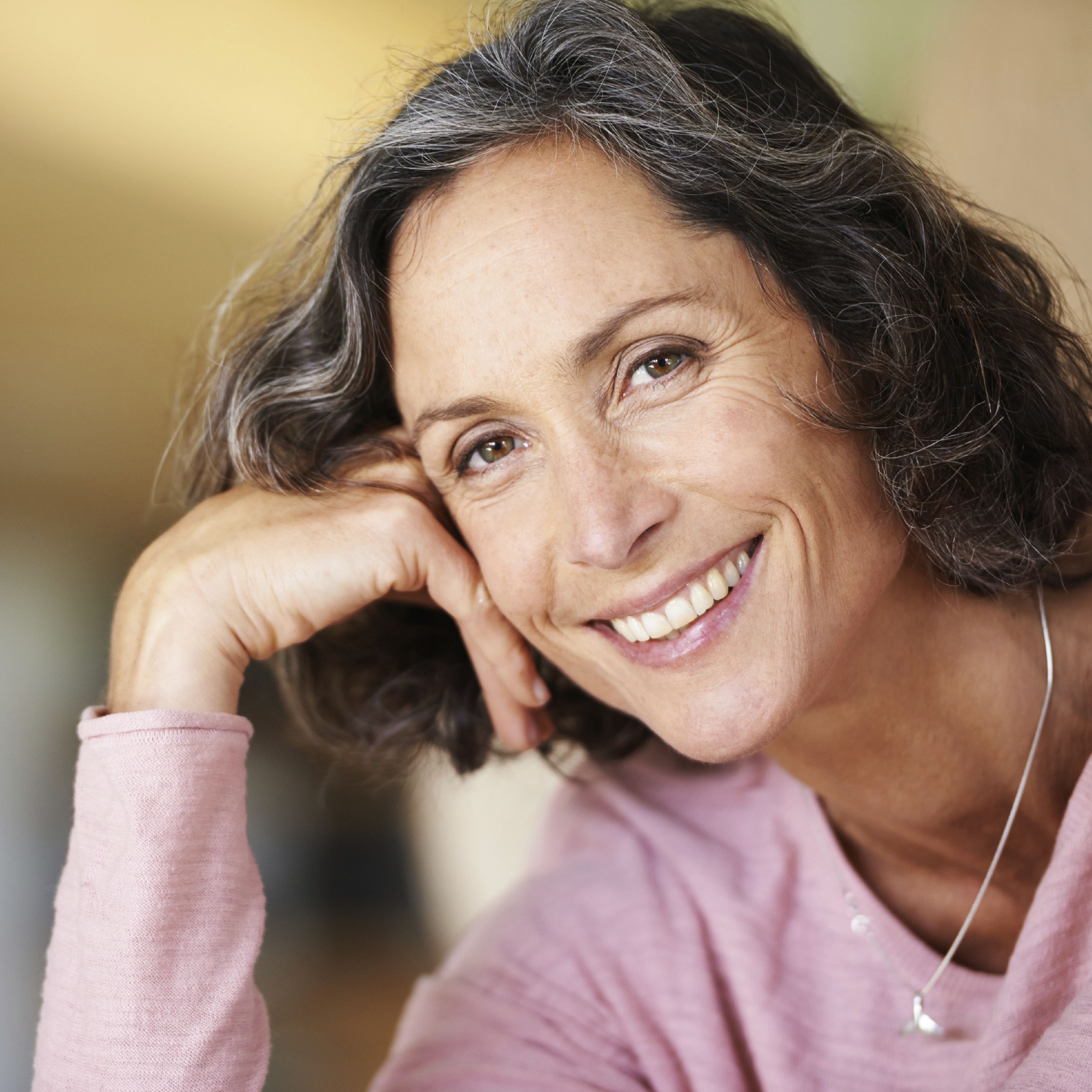 Head and shoulders of older woman smiling into camera